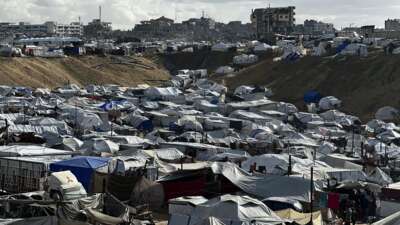 Dozens of makeshift tents stretch across a flooded and muddy landscape in the Al-Mawasi area of the Gaza Strip on November 25, 2025. Heavy rainfall and a strong weather front caused severe flooding across the area submerging roads, damaging tents, and disrupting movement for displaced families.
